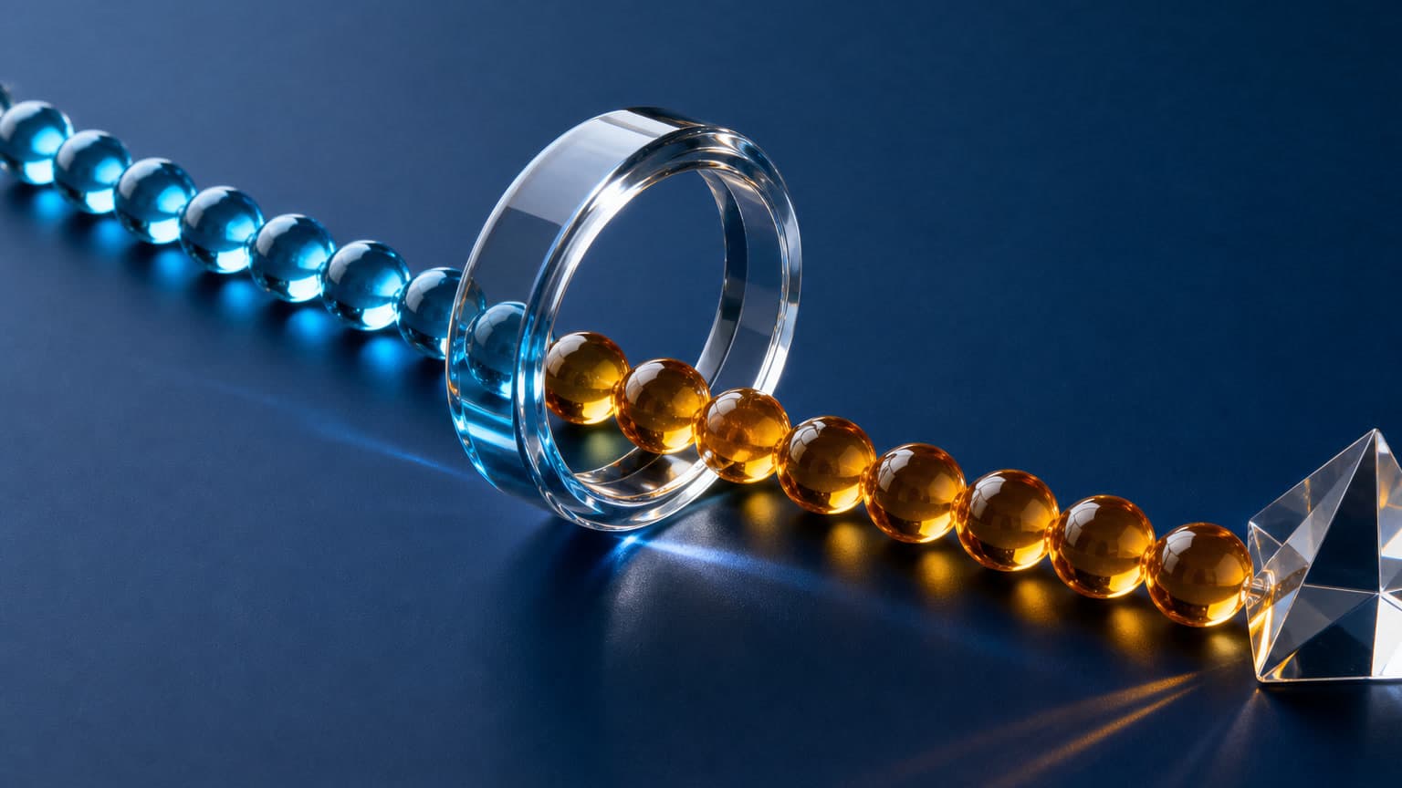 Blue and amber glass beads meet at a clear ring, while the amber beads continue toward a faceted glass prism.